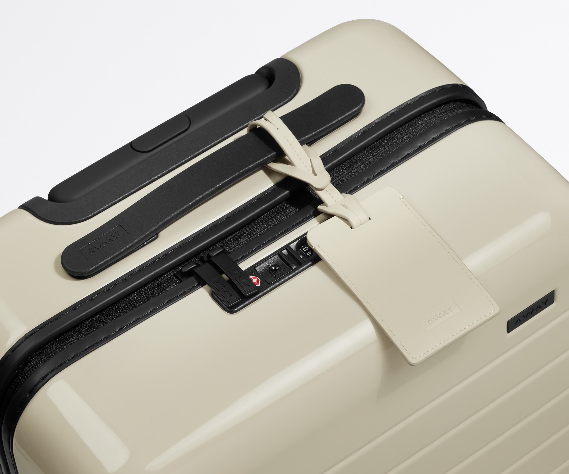 The leather luggage tag on top of a matching Away suitcase