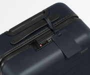 The leather luggage tag on top of a matching Away suitcase