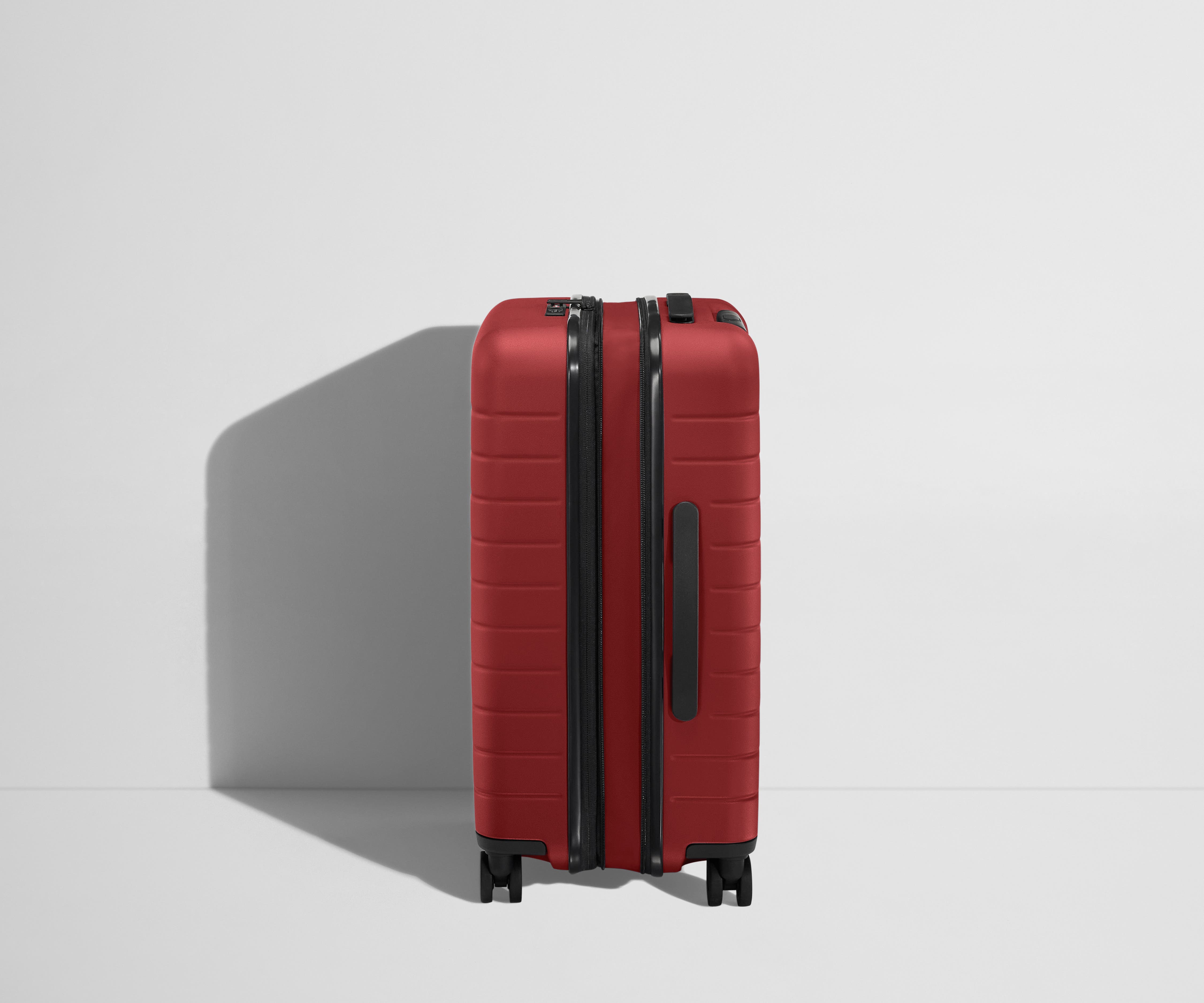 Side product view of The Bigger Carry-On Flex suitcase in Tango Red shown fully expanded