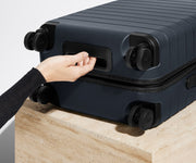The Carry-On suitcase in Navy Blue shown from below highlighting the underside grab handle
