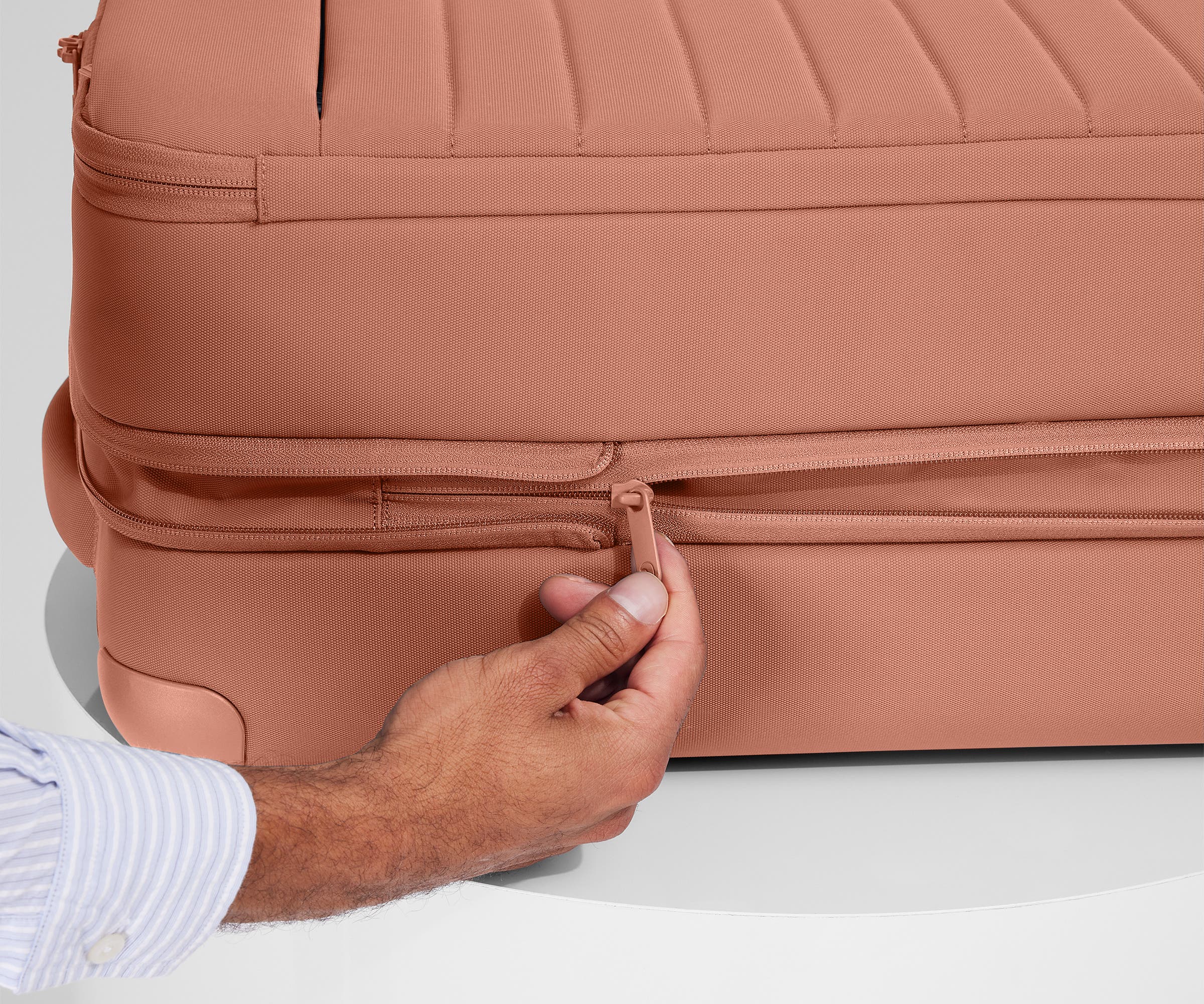Person expanding the bag, using the wraparound zipper