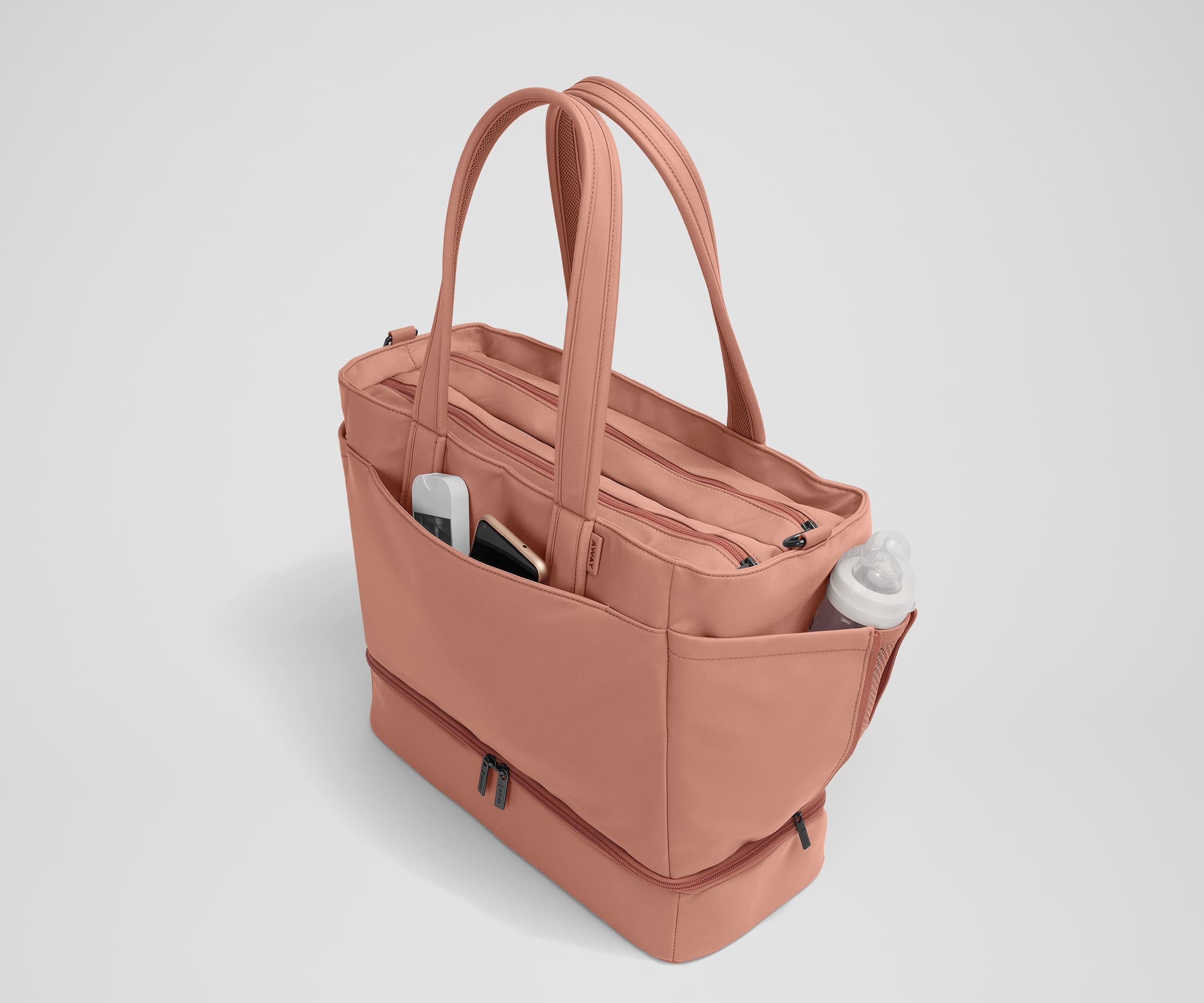 Exterior front pocket packed with hand sanitizer and a phone. Exterior bottle pocket packed with a milk bottle