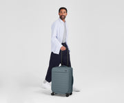 Person standing next to the Softside Bigger Carry-on for scale