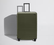 Front product view of The Large Flex suitcase in Olive Green with raised handle