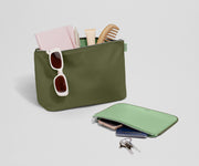 Pouch duo packed with travel essentials like a notebook, passport, keys, and sunglasses