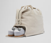 A pair of sneakers in the zippered shoe compartment