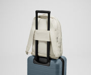 Back view of the Courtside Everywhere Zip Backpack on top of an Away suitcase