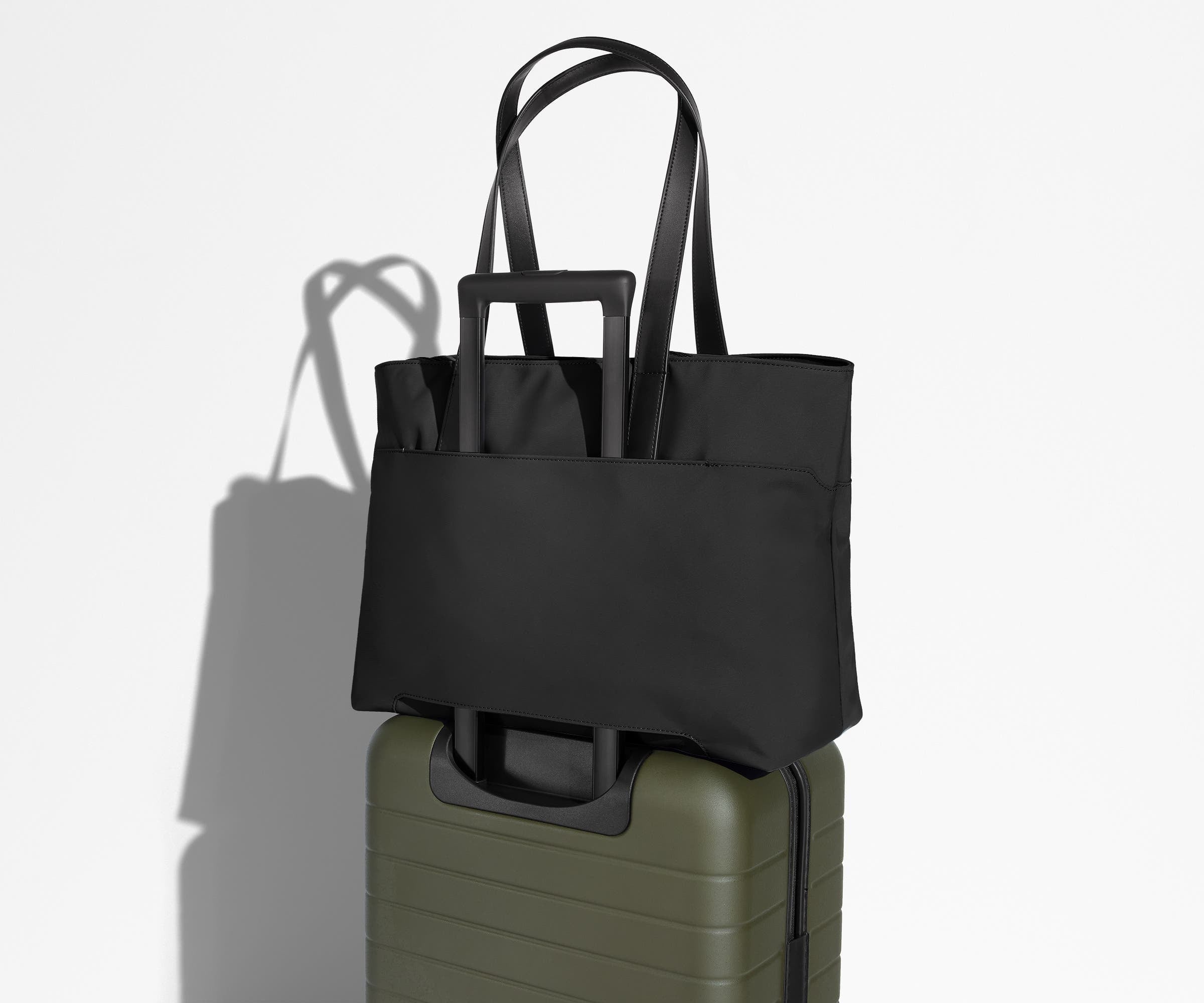 Everywhere Tote secured to an Away suitcase by its trolley sleeve