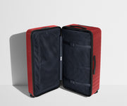 The Trunk suitcase in Tango Red shown open in an upright position to show interior organization and compression system