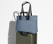 Everywhere Tote secured to an Away suitcase by its trolley sleeve