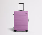 Front product view of The Medium suitcase in Taffy Purple with raised handle