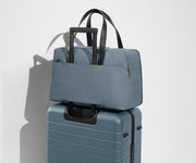 The Overnight Bag secured to an Away checked suitcase using the trolley sleeve