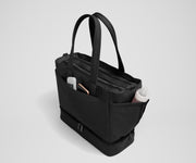 Exterior front pocket packed with hand sanitizer and a phone. Exterior bottle pocket packed with a milk bottle