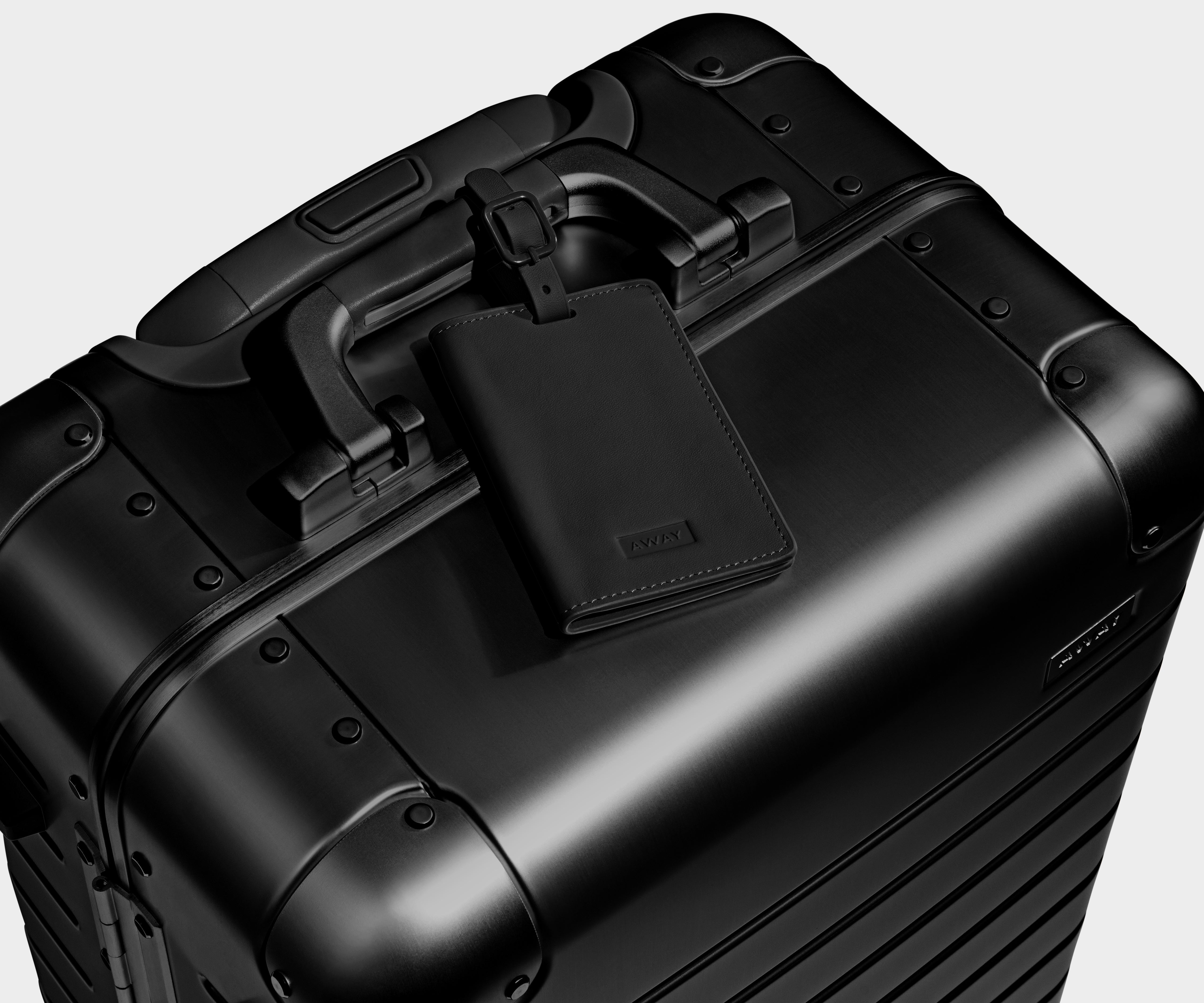 Black leather luggage tag that comes with the Aluminum suitcase