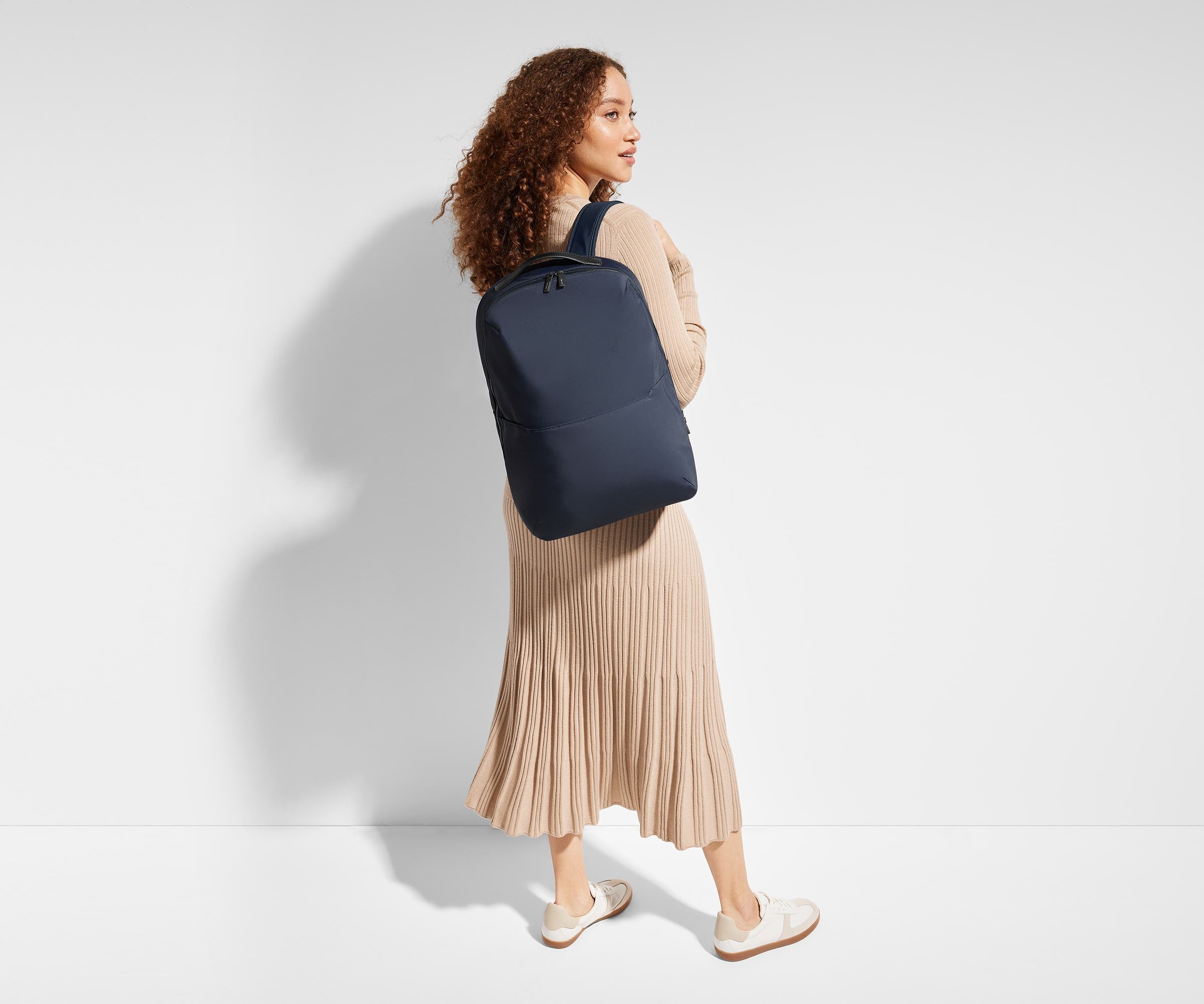5'9" person wearing a Navy Blue Everywhere Zip Backpack on one shoulder