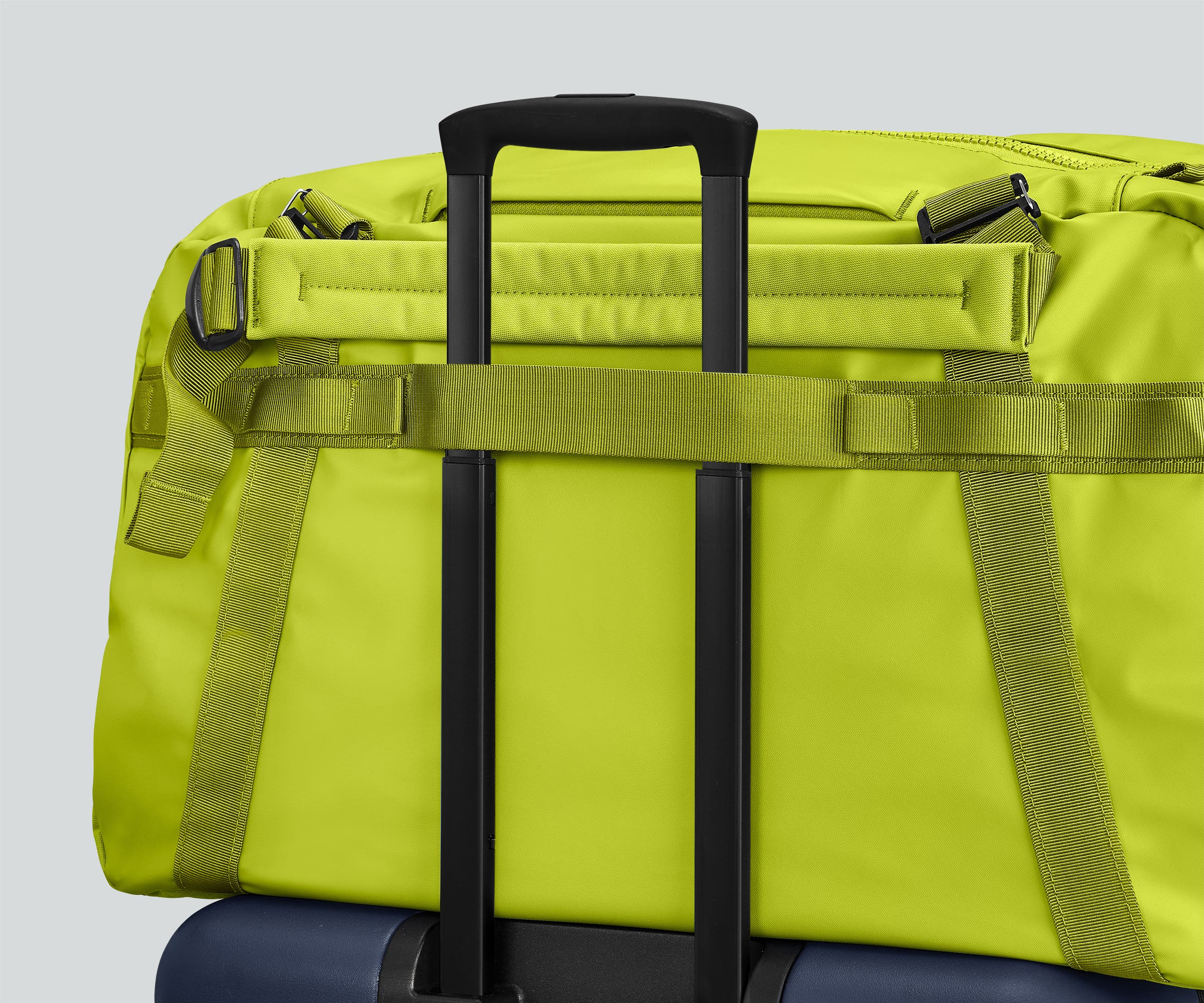 55L duffle bag secured to an Away suitcase by the trolley sleeve