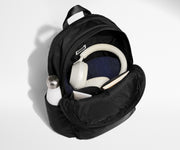 Front compartment packed with a notebooks, headphones, and clothing