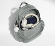 Gray backpack with items like a water bottle and jeans on a white background