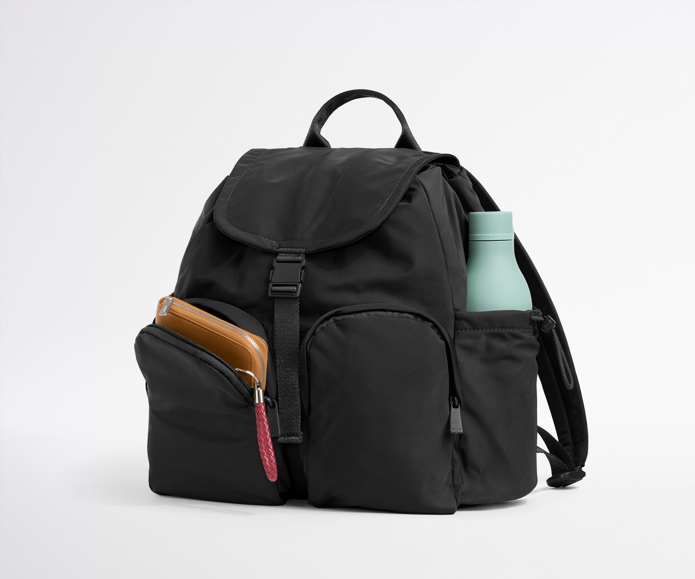 Black backpack with a phone case and water bottle on a light gray background