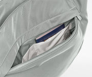 Gray bag with a pocket containing a passport and money on a white background
