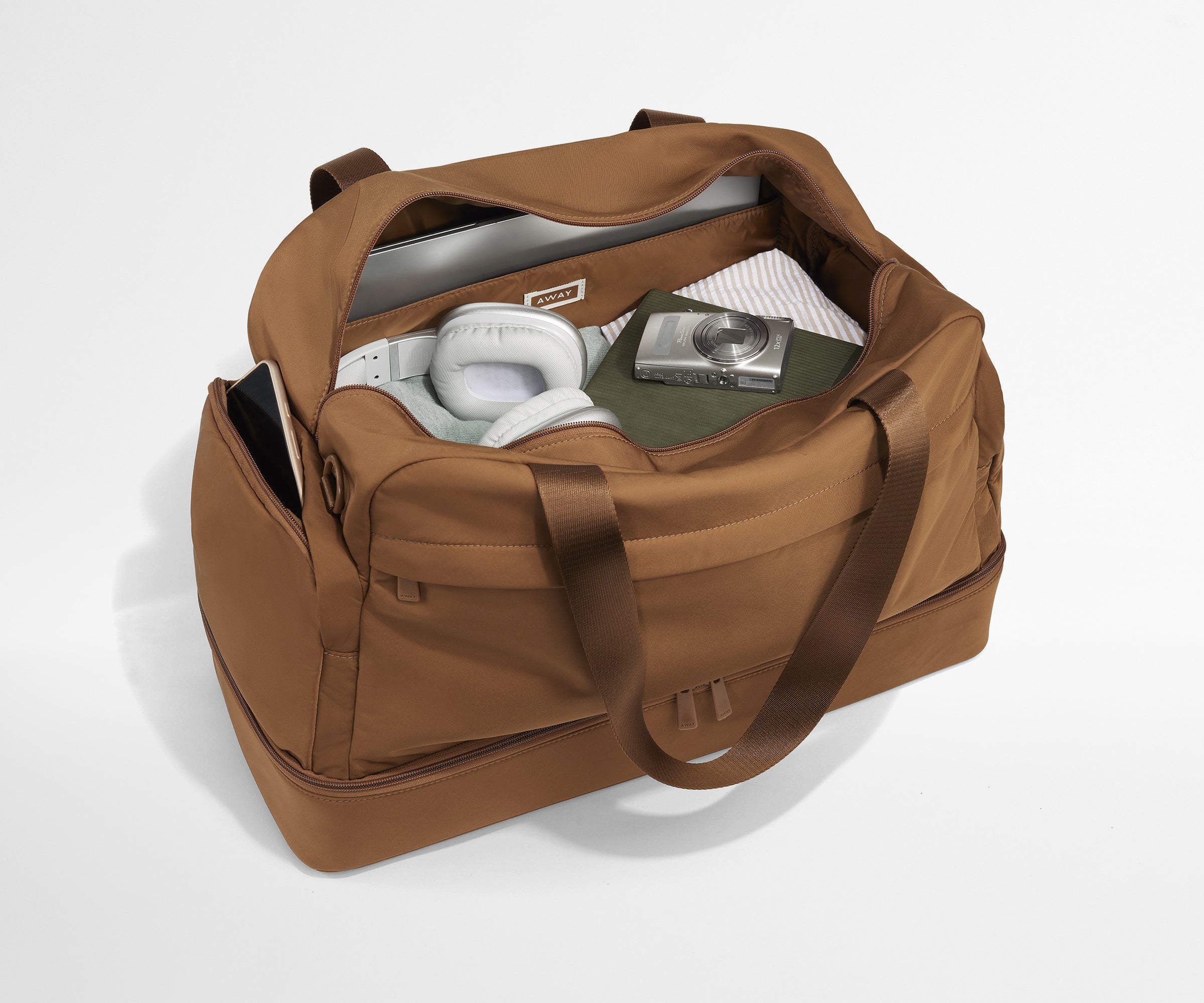 Person packing the Featherlight Weekender with various travel essentials
