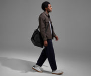 Person wearing the Featherlight Weekender as a crossbody with the detachable strap