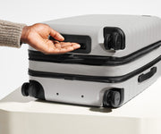 The Carry-On Flex suitcase in Cloud Gray shown from below highlighting the underside grab handle