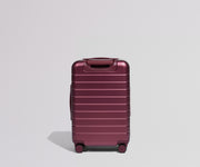 Maroon suitcase on a light gray background