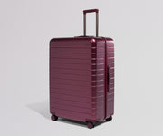 Maroon suitcase on a light gray background