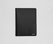 Black leather passport holder with 'AWAY' branding on a light gray background