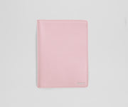 Pink leather passport sleeve on a light gray background