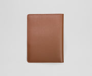 Brown leather passport holder on a light gray background