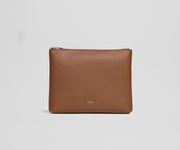 Brown leather pouch with 'AWAY' branding on a light gray background