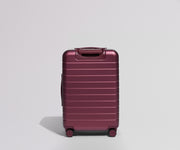Maroon suitcase back view on a light gray background