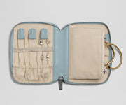 Jewelry case with compartments for earrings and a key, on a light gray background