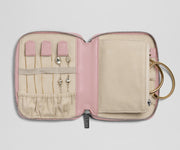 Pink jewelry case with compartments for earrings and a ring on a light gray background