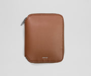 Brown leather jewelry organizer with 'AWAY' branding on a light gray background