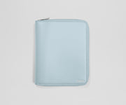 Light blue travel wallet with an AWAY logo on a light gray background