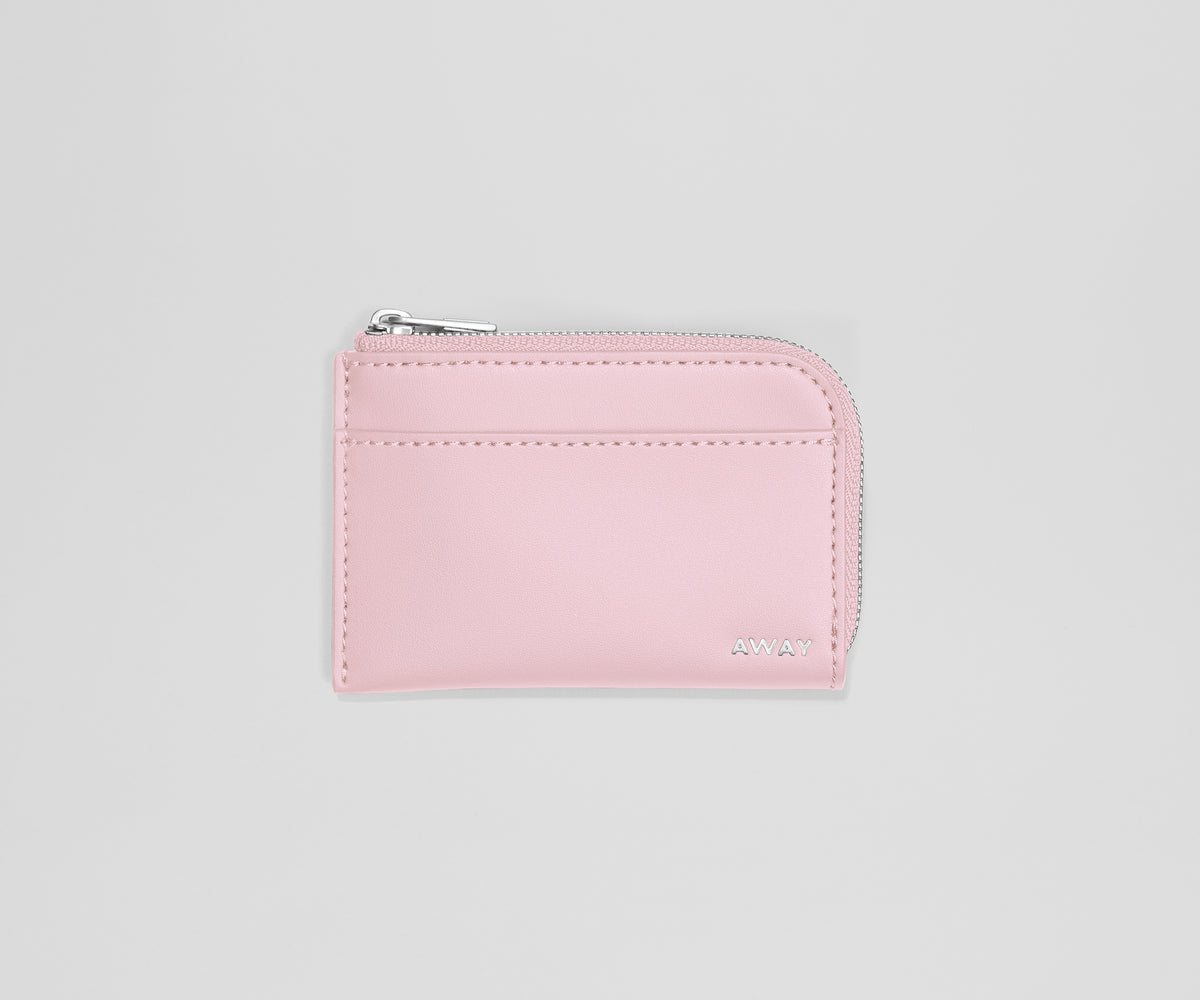 Pink wallet with a zipper on a light gray background