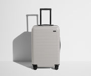 Front product view of The Bigger Carry-On suitcase in Cloud Gray with raised handle