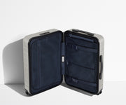The Carry-On suitcase in Cloud Gray shown open in an upright position to show interior organization and compression system