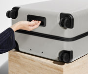 The Medium suitcase in Cloud Gray shown from below highlighting the underside grab handle