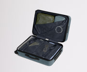 The Bigger Carry-On suitcase in Coast Blue shown open on its side and packed with Away's packing organizers to show capacity and the interior compression system, designed to help you pack more in