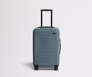 Front product view of The Carry-On suitcase in Coast Blue with raised handle