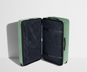 The Trunk suitcase in Sea Green shown open in an upright position to show interior organization and compression system