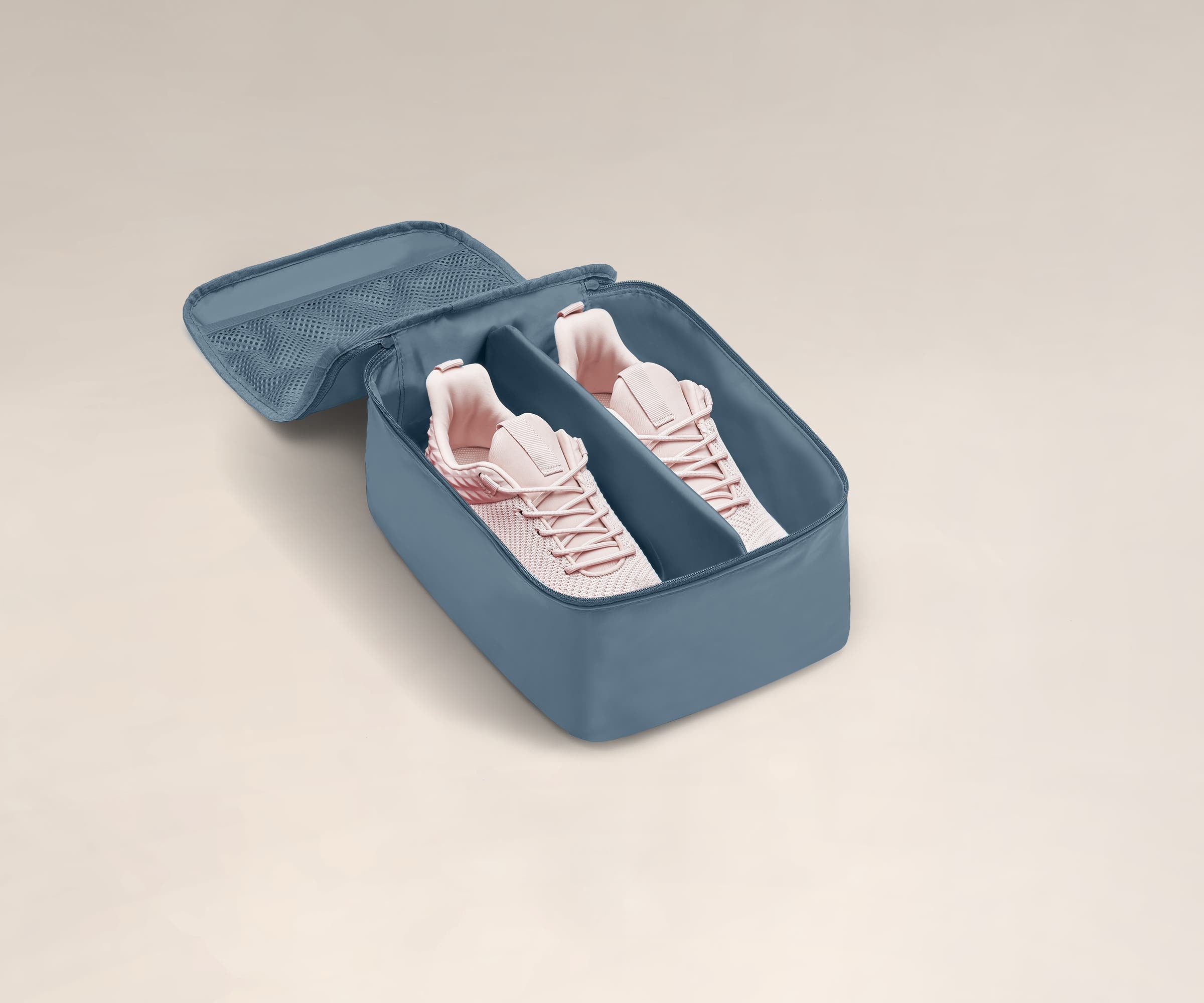 A pair of sneakers in a small Shoe Cube