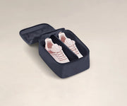 A pair of sneakers in a small Shoe Cube