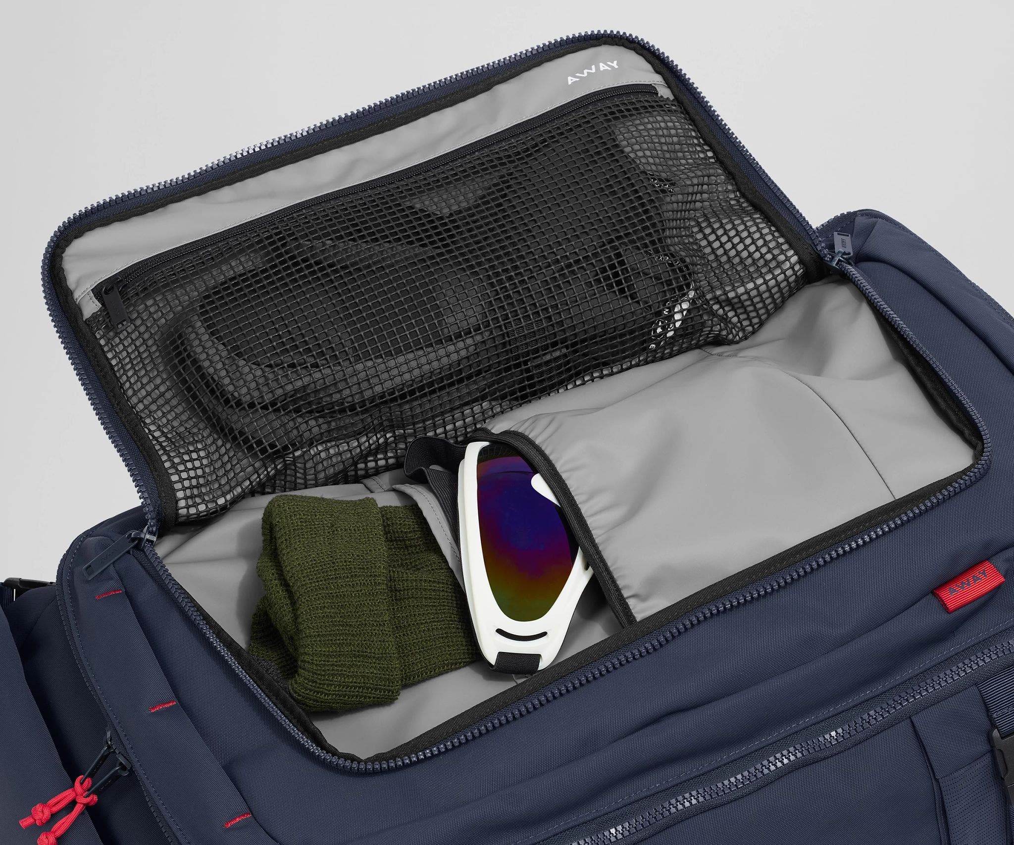 Gloves, beanie, and ski googles packed in the front flap pocket