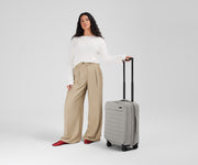 5'7" person standing next to the Softside Carry-on for scale