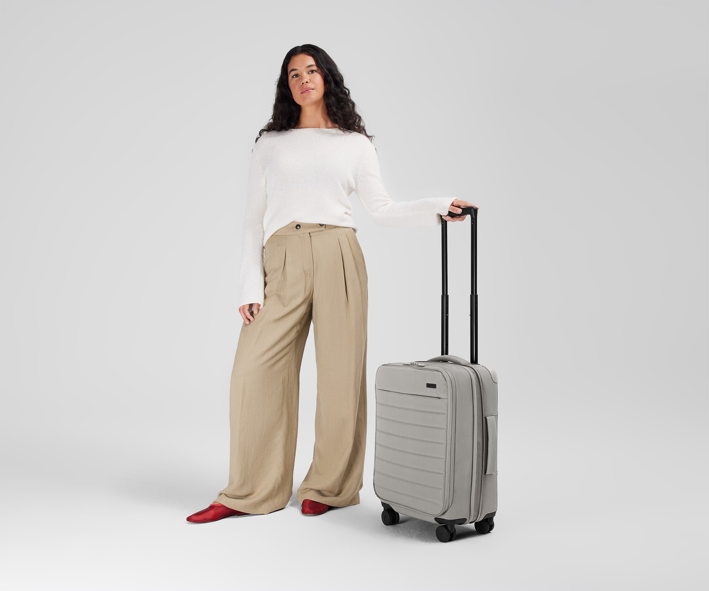 5'7" person standing next to the Softside Carry-on for scale